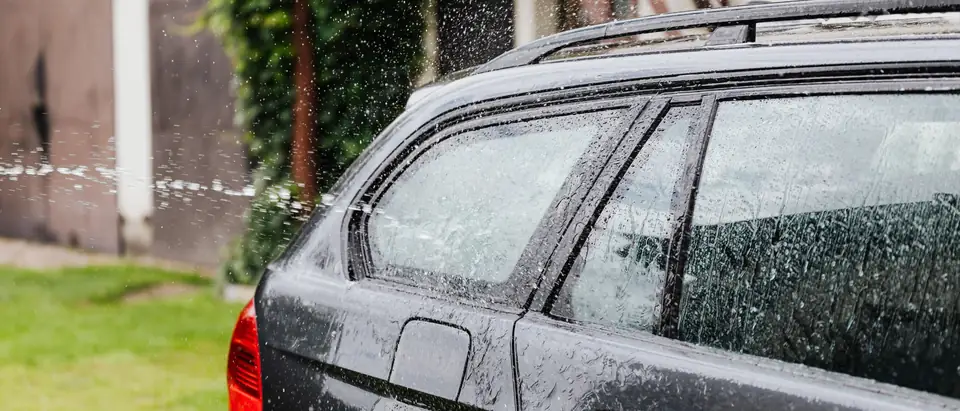 Rain on the side windows of a dark estate car
