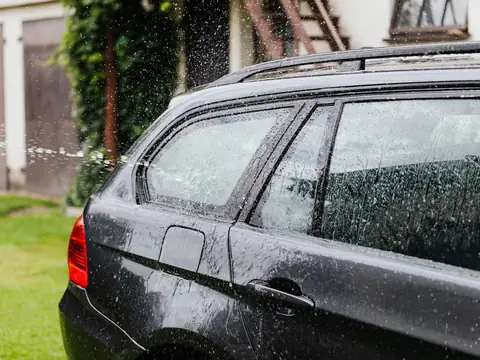 Rain on the side windows of a dark estate car